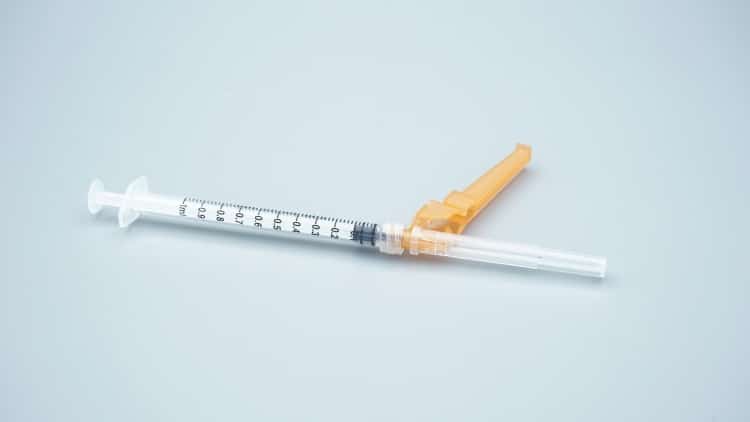 healthcare-professional-administering-vaccine-injection-using-safety-syringe-hospital-setting