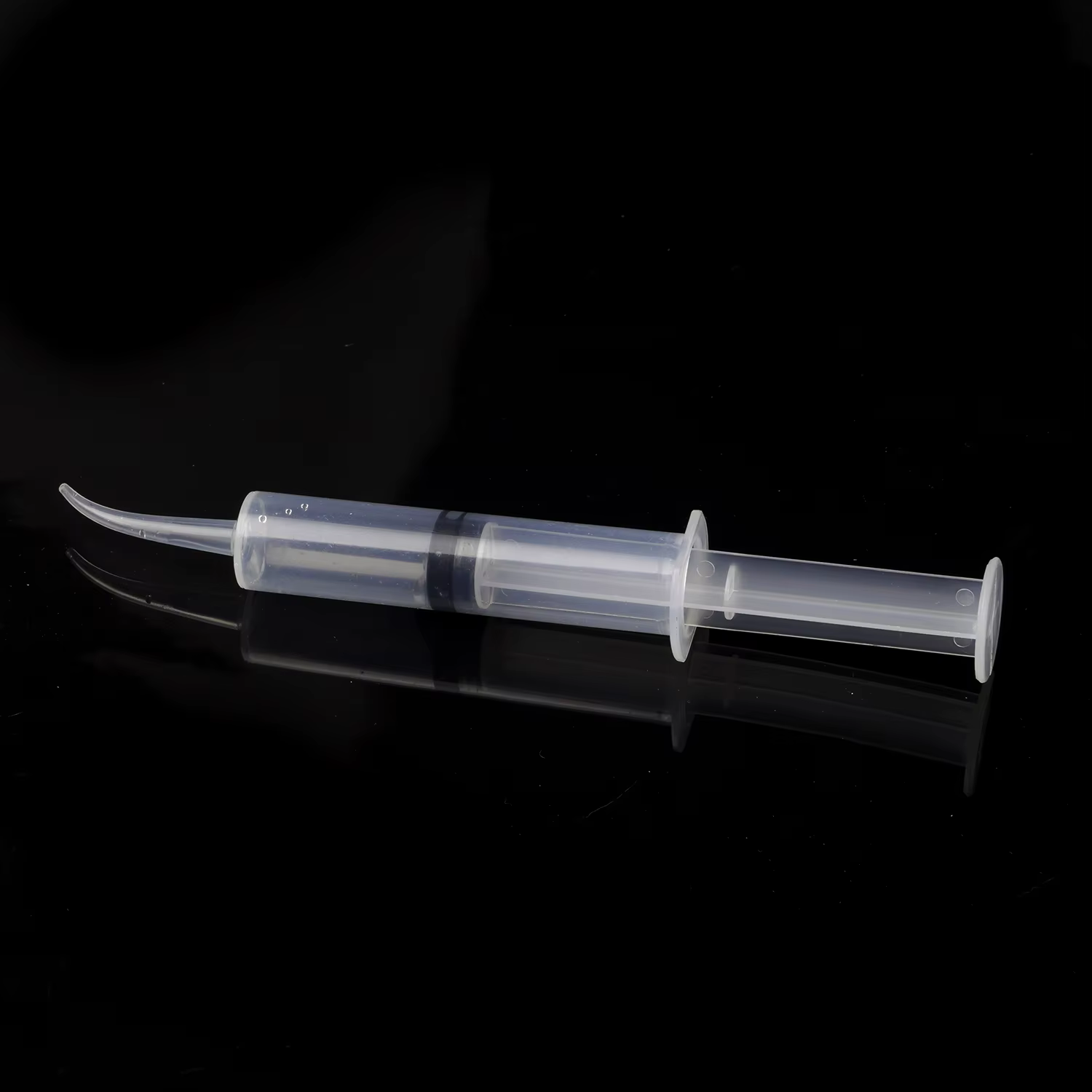 Plastic dental syringe side angle showing bent tip design for surgical irrigation